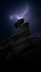 Lightning strikes rock formation at night in a dramatic and powerful landscape scene