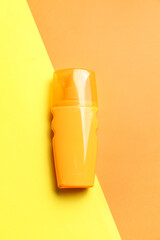 Bottle of sunscreen cream on color background