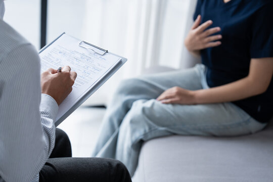 sad female sitting on sofa Patient discussing mental health issues with psychologist. depressed asian woman mental health treatment - Powered by Adobe
