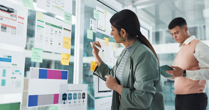 Woman, writing and glass wall for app development, notes and team with documents, charts and review. People, board and tablet for brainstorming, software innovation and ux design at digital agency - Powered by Adobe