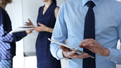 Business professional hands using a tablet during an office meeting, collaborating and discussing new strategies with colleagues in a corporate environment