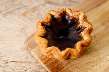 coffee Portuguese sweet dessert egg tart on wooden table.