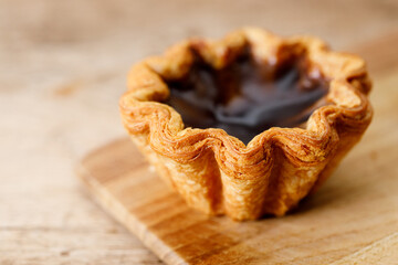 coffee Portuguese sweet dessert egg tart on wooden table.
