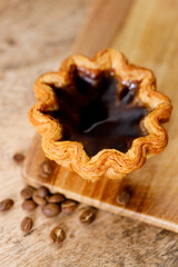 coffee Portuguese sweet dessert egg tart on wooden table.