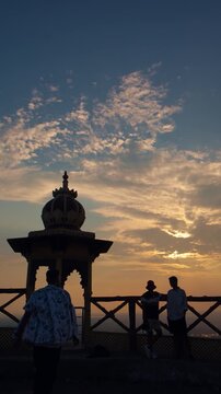 Young man enjoying the sunset and evening view at Samai Mata Mandir, Banswara, near Udaipur, Rajasthan, India, raising his hand in satisfaction while admiring the beautiful landscape.