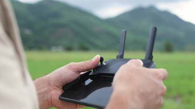 A hand adjusts the antenna on a quadcopter remote control.