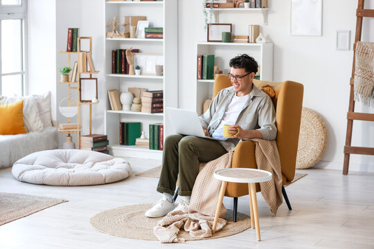 Male screenwriter with laptop and coffee writing script in office
