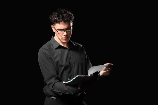 Male screenwriter reading scenario on dark background