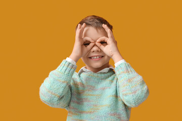 Little boy showing OK on yellow background