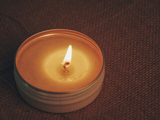 Scented candles glowing on a burlap sack at night, creating a romantic and warm atmosphere. Perfect for concepts of relaxation