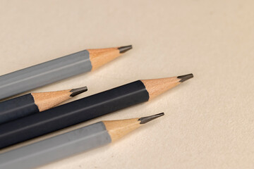 a row of black pencils folded on cheap loose paper, wooden pencils with graphite lead for drawing or other work