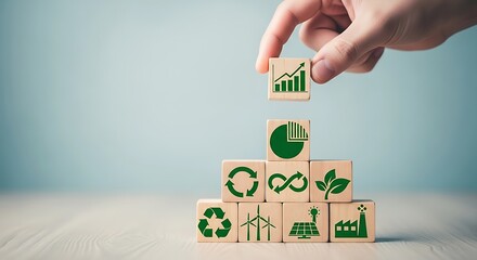 Hand stacking wooden blocks with icons representing sustainability, growth, and environmental responsibility, symbolizing a circular economy and green business