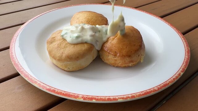 Pouring Southern Sausage Gravy on Biscuits 