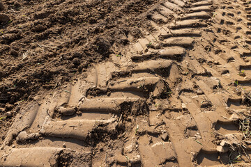 traces of a tractor on the soil during tillage, soil in a field with traces of passing heavy agricultural machinery after tillage