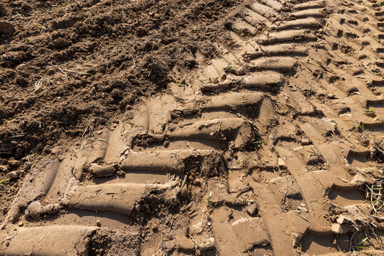 traces of a tractor on the soil during tillage, soil in a field with traces of passing heavy agricultural machinery after tillage