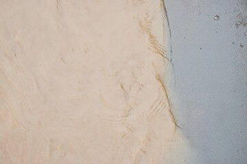 Closeup of sand and water creating a natural pattern on the beach