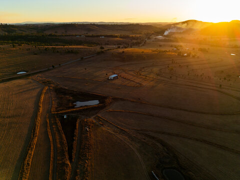 Sunset of golden brown paddocks dotted with small dams