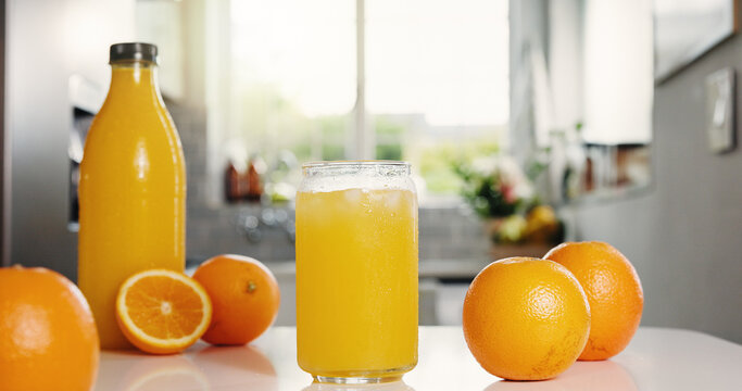 Nutrition, bottle or glass in kitchen with orange juice, antioxidant or vitamin benefit in morning drink. Organic, hydration or fruit in house for digestion, gut health or detox in breakfast beverage - Powered by Adobe