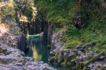Tourist people sailing rowboat over blue water of Takachiho gorge, Miyazaki