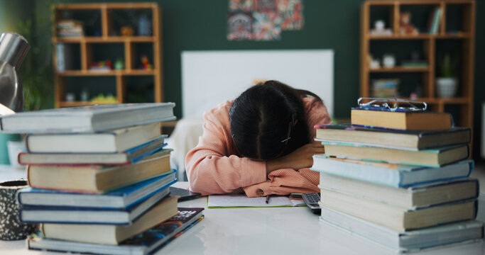 College student, books or girl with sleeping in home for learning break, study fatigue or overworked. Low energy, person and resting at desk for exam revision, academic workload and semester burnout