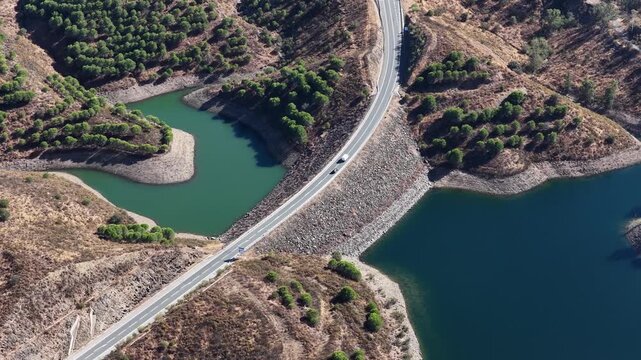 Cars driving on a road near a reservoir with water scarcity
