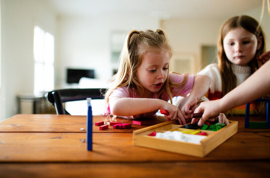 Young girl with ponytail getting rectangular blocks from the box