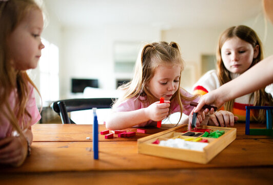 Young girls in ponytail getting rectangular blocks from the box
