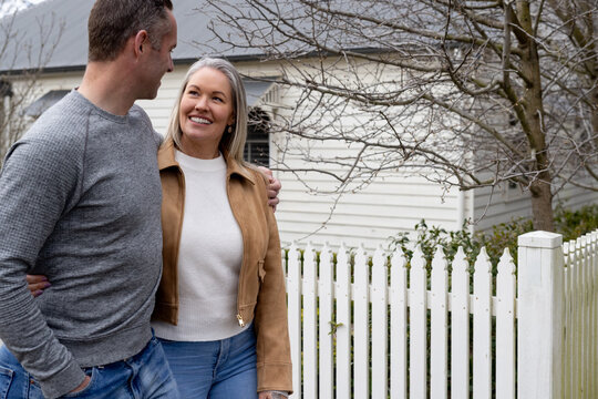 Couple walking outside picket fence