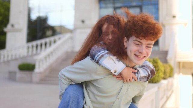 Redhead siblings playing piggyback ride outdoors with laughter and joy - Powered by Adobe
