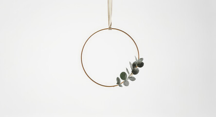 Minimalist gold hoop wreath with eucalyptus branch for elegant holiday decorations or modern botanical designs, perfect for seasonal projects