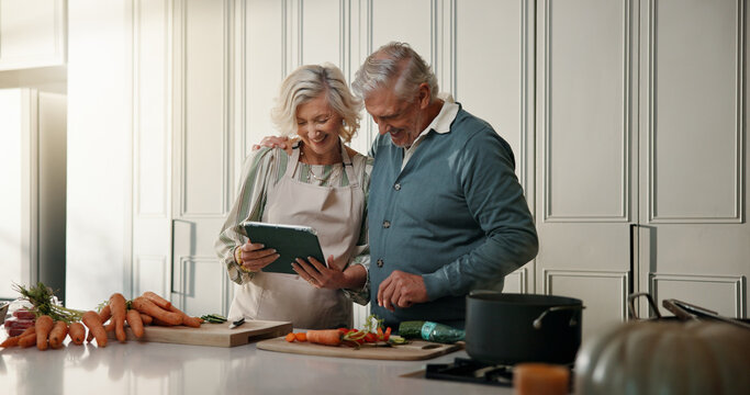 Senior, couple and tablet with online recipe in kitchen for cooking tutorial or tips in home. Man, woman or research with technology, ingredients or vegetables for meal prep, guide or instructions