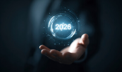 Palm of a man holding a digital rendering of the year 2026 in blue hues