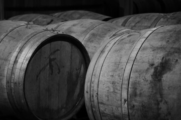 black and white image of dusty wooden barrels of rum in a large storage © AE & mekke