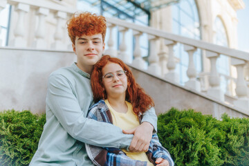 Happy redhead siblings hugging outdoors with smiles and family warmth