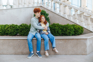 Redhead children showing emotional bonding with hug near modern railing