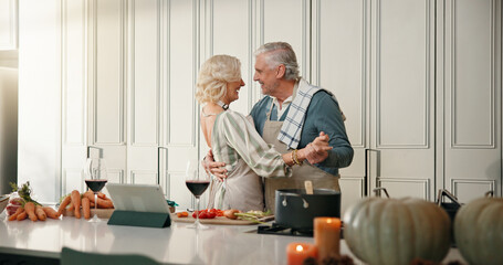 Cooking, dance and old couple in kitchen for lunch, supper and online recipe for bonding in home. Wine, retirement and senior man and woman for meal prep, tablet and support for anniversary dinner