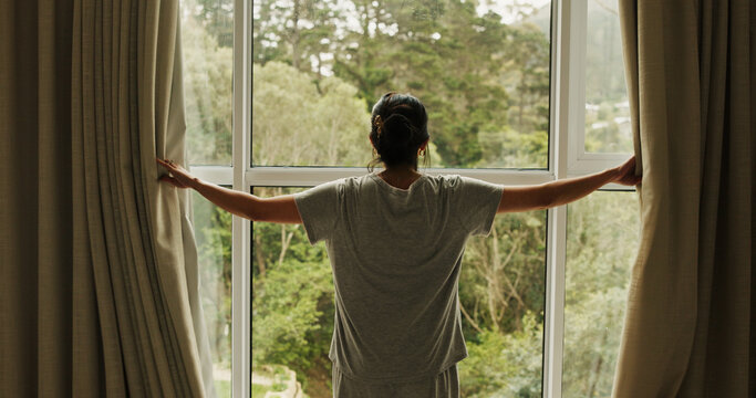 Wake up, window and back of woman in hotel room for morning routine, accommodation getaway and relax. Curtain, hospitality and view with person in house rental for comfortable, trip and sunrise