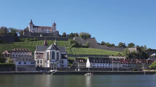 Summer skyline of W&uuml;rzburg, Germany with the Marienberg Fortress, the St. Burchard's Abbey and the vineyards of the Marienberg. Bavarian castle on a sunny day with the River Main in the foreground.