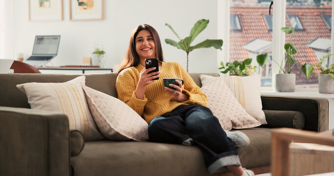 Woman, phone and thinking with coffee on couch, texting or smile with online dating chat in home. Person, smartphone and decision with cup, relax and mobile app for social media on sofa at apartment