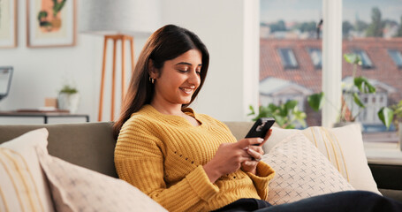 Phone, smile and woman on sofa in home with networking, communication or social media on mobile...