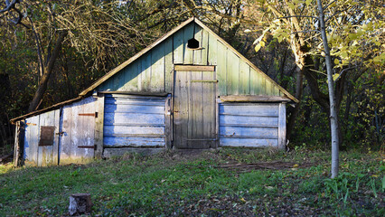 Ukrainian village house, surrounded by trees in the garden and greenery. A glimpse into traditional rural life and folk architecture. A house in a village, a summer cottage, a wicker fence in the yard