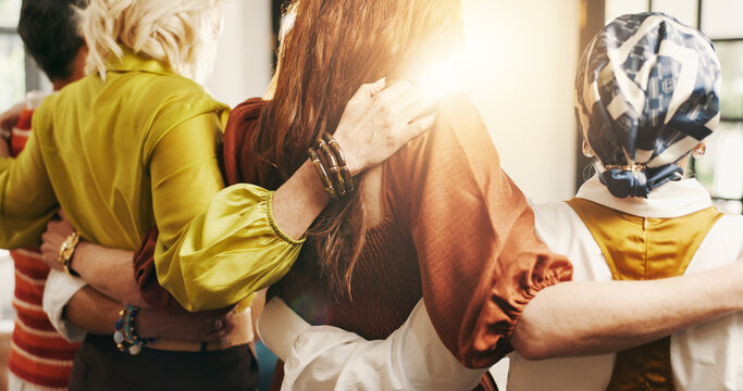 Hug, women and friends in home with comfort, solidarity and bonding together at gathering. Flare, support and back of female people embracing in group for trust, connection and care in house.