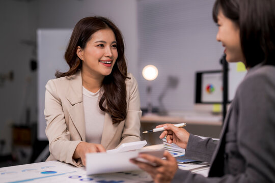 Asian businesswomen discussing work evaluating financial data