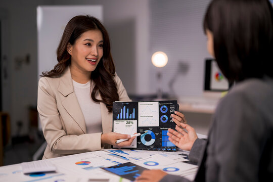 Businesswoman presenting data analysis dashboard to colleague in office