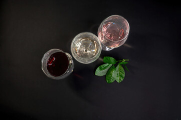 Row of three wine glasses on black background