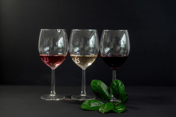 Row of three wine glasses on black background