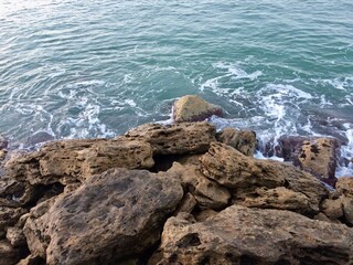 Rocky Coastline with Ocean Waves Splashing against Natural Stone Shore