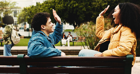 Happy people, student and bench with high five for success, learning or education on campus. Excited, man and woman with smile for congratulations, winning or teamwork together in outdoor university
