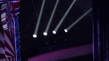 Close-up of stage lighting in a dark theater. Bright beams of light shine through the darkness, creating a dramatic and moody atmosphere. Ideal for event, concert, and lighting concepts