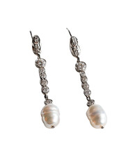 Pearl drop earrings, ornate metal, hanging on black